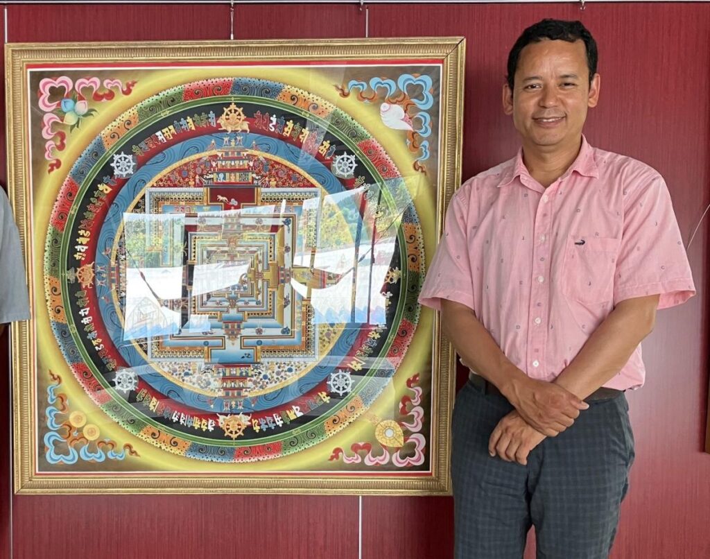 Dhalma Lama with a Tibetan Buddhist mandala painting of his own creation