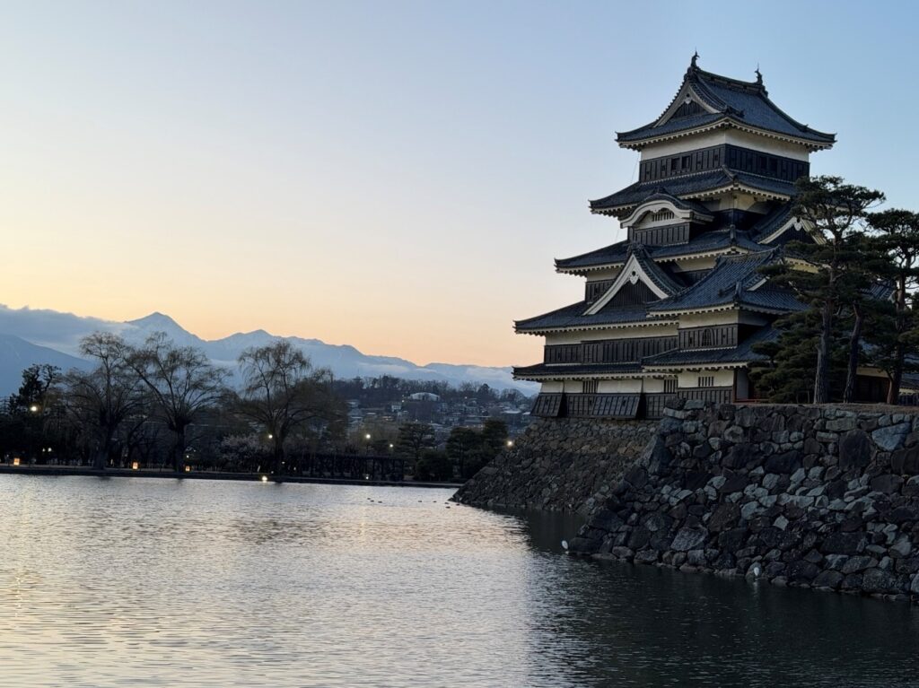 Matsumoto Castle at dusk, with the Northern Alps rising in the background